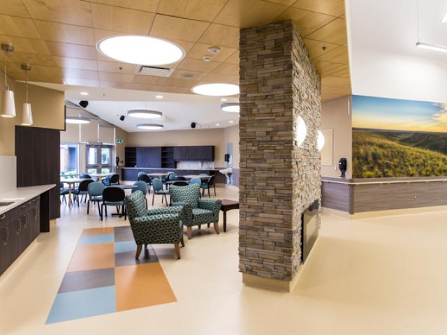 Kerrobert Integrated Healthcentre. Interior showing fireplace, dining area and wall with large mural.