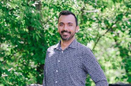 Man standing in front of a collection of trees
