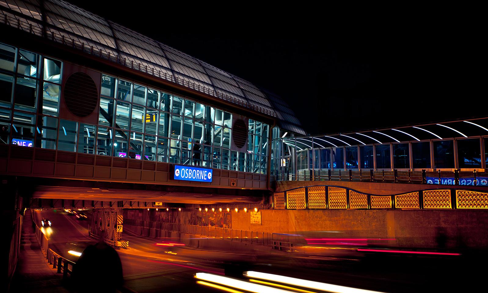 Osborne Bus Rapid Transit Station. The station at night from the street showing how the traffic disappears into an underpass below the illuminated station. 