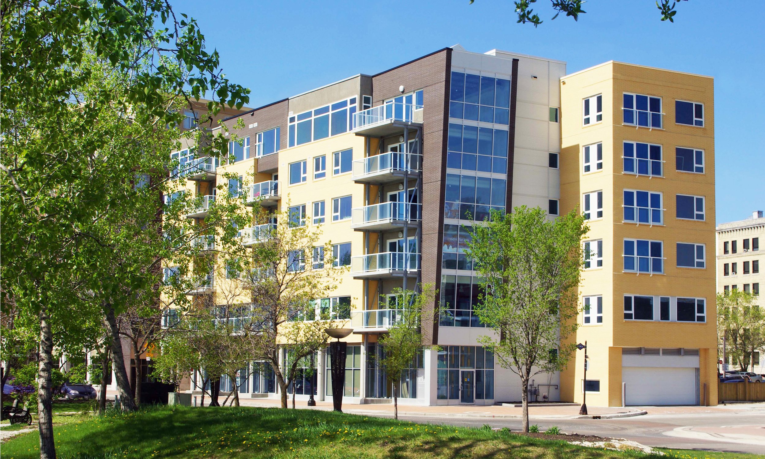 A mid-rise building surrounded by green and lush landscape