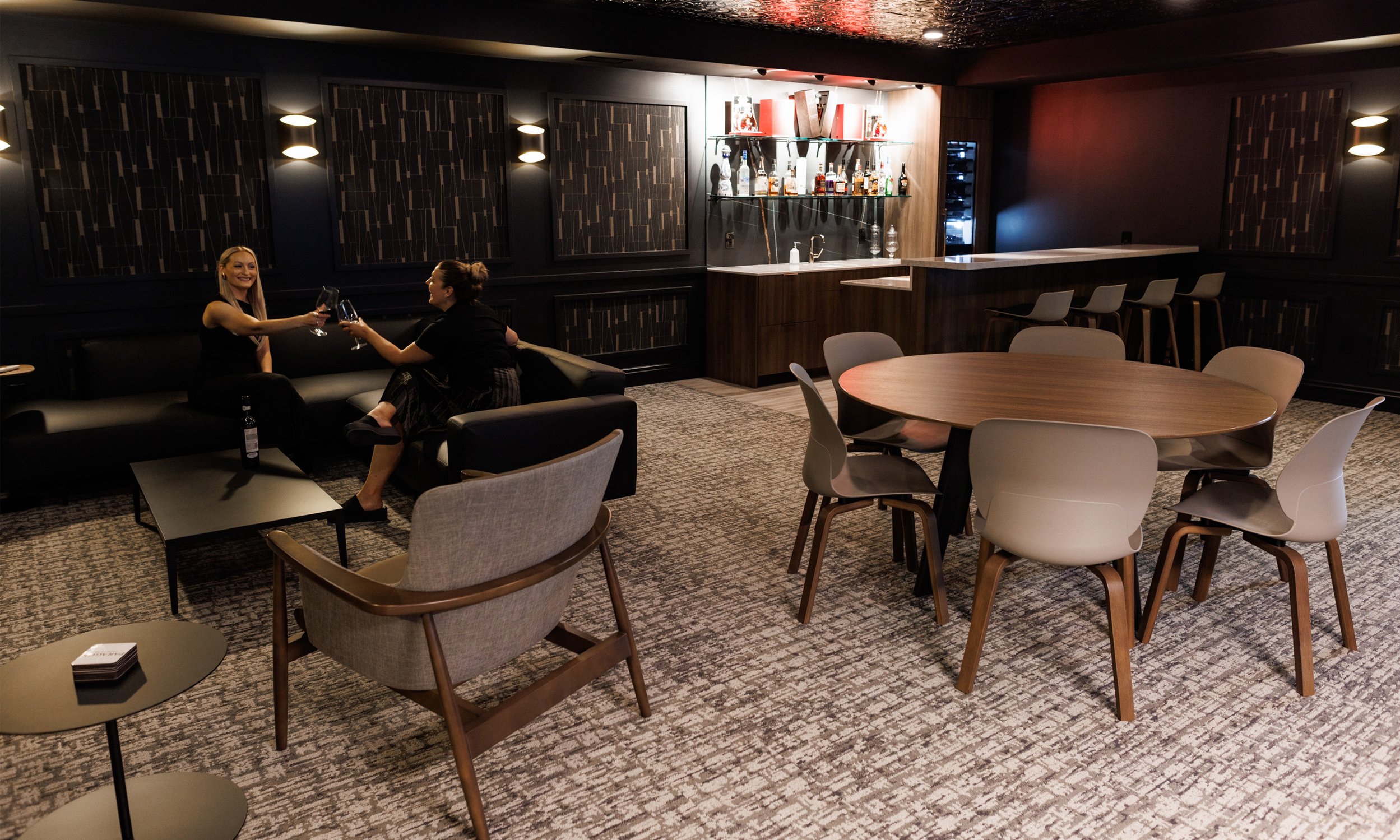 Two women clink wine glasses in a Gatsby-inspired lounge