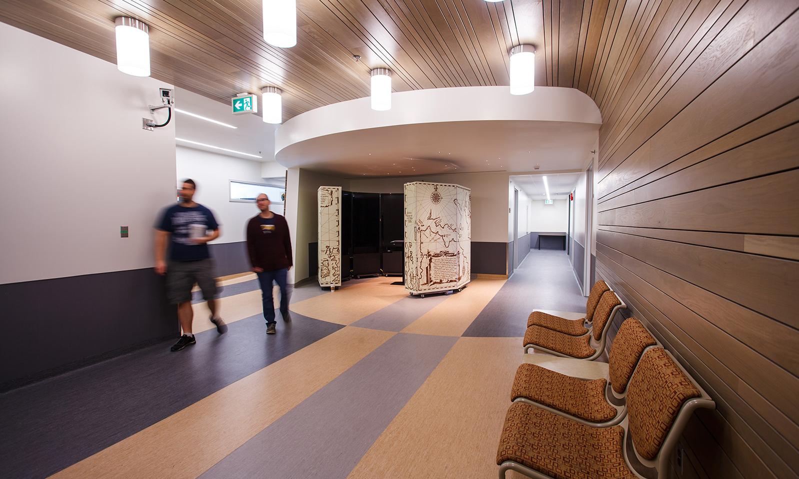 University of Manitoba, Wallace Building. Corridor opens into a central area inlaid with broad bands of purple-grey and pale blonde flooring. 
